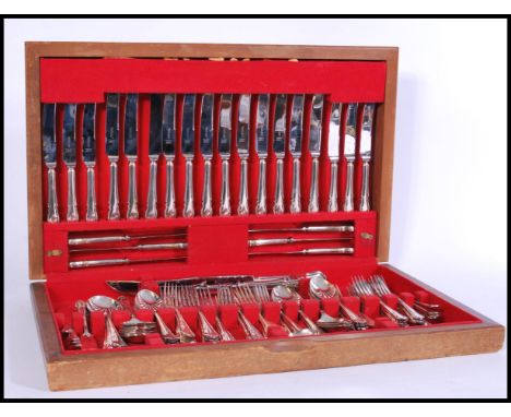 A large 20th century canteen of silver plated cutlery set within a light oak canteen case with red baize lining. The flatware