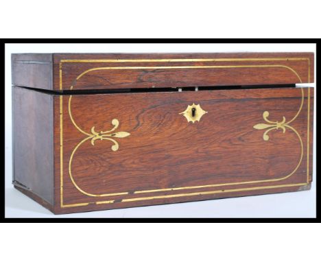 A 19th century rose wood tea caddy with brass inlay to the top and sides, having a shaped scutcheon, two lead lined tea cases