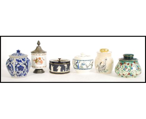 A selection of vintage tobacco jars to include a lustre jar with a pelican design to the side and large finial lid, a Bursley