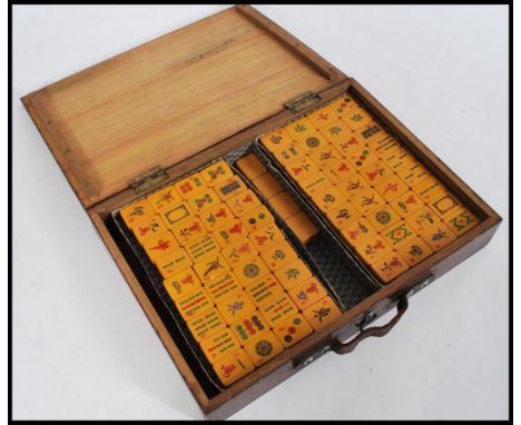 A set of early 20th century Mahjong game bakelite / lucite&nbsp;tiles bearing character marks and motifs in a wooden carry ca