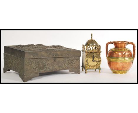 A Japanese metal box having ornate peony embossing to the lid and sides on four feet with a hinged lid and lock to the front,