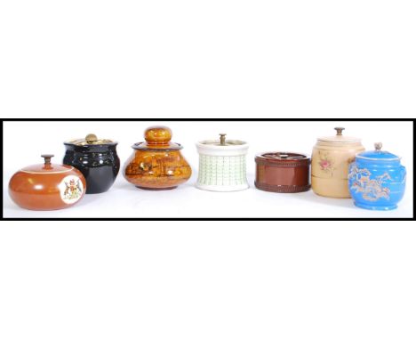 A selection of vintage tobacco jars to include a brown bulbous form jar with a travelling scene printed to the outside having