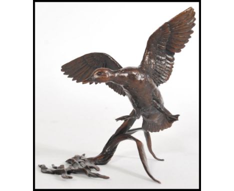 A bronze figurine of a goose in flight with reeds and water, by Michael Simpson, stamped MS to to the base, limited edition n