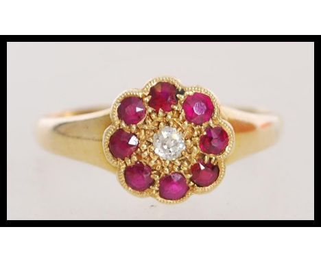 A late 19th century Victorian hallmarked 18ct gold cluster ring with an approx 5pts central diamond with halo of 8 rubies . H