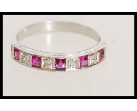 A stamped 18k white gold ring with channel inset alternating diamonds and rubies. Marked 18ct tests 18ct gold. Weight 2.7g. S