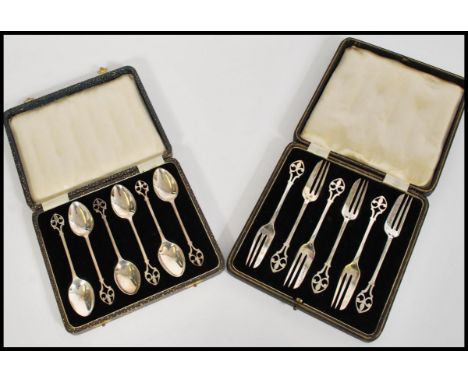 A cased set of silver hallmarked teaspoons, surmounted with a Fleur De Lys fret pierced finial, Birmingham 1931, Price Brothe