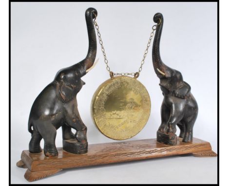 A 1920's Burmese elephant gong. The table top gong with hand beaten brass gong suspended from chains and raised trunk elephan