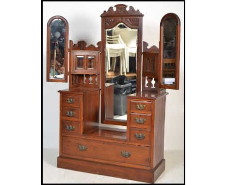 An Edwardian walnut batwing triple mirror dressing table chest of drawers. Raised on a plinth base with a bank of drawers. Ab