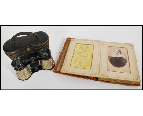 A 19th century Victorian photograph album containing portrait photographs along with a pair of vintage cased binoculars with 