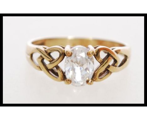 A 20th century hallmarked 9ct gold ring with a large oval cut white stone in a prong setting having pierced celtic knot detai