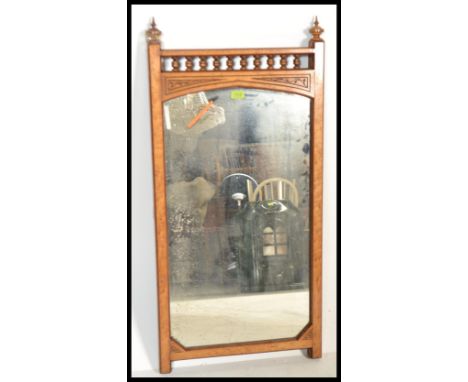 A Victorian architectural wall mirror in satin wood having gallery and finial top