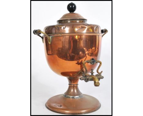 A Victorian copper and brass twin handled samovar complete with the tap to front having a rococo pull handle pourer, finial t