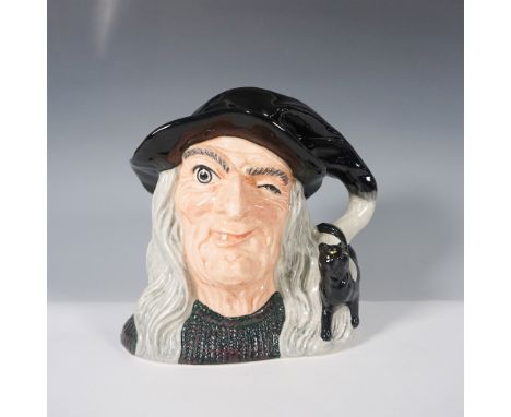 This striking jug depicts a winking witch with long flowing gray hair, a black pointed hat, and a black cat perched on the ha