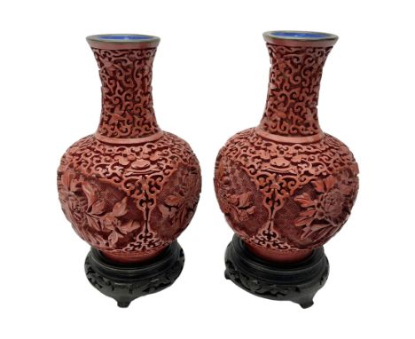 Pair of Chinese cinnabar lacquer vases, each of bulbous baluster form, carved with peonies and foo dogs amongst scrolls, with