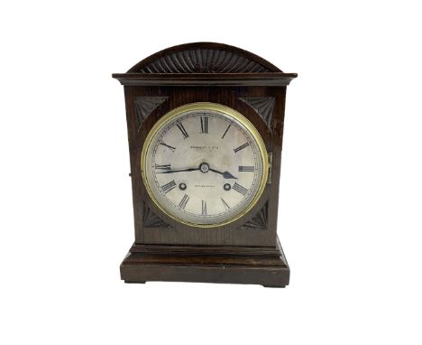 German - Early 20th century eight-day mantle clock, in an oak case with an elliptical top and carving to the front of the cas