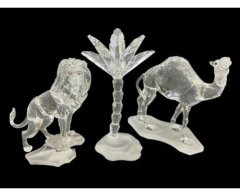 Swarovski Crystal animals, comprising camel and lion, both upon frosted crystal bases, together with Swarovski Crystal palm t