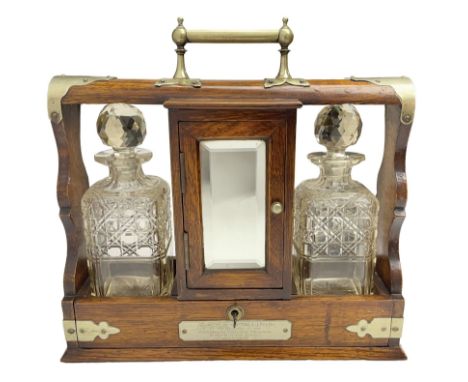 Early 20th century oak tantalus with silver plated mounts and handles, with two recesses, each containing a cut glass decante