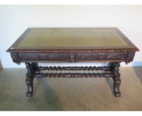 A Victorian oak sofa table writing desk with green leather and gilt tooled top over two carved frieze drawers, the legs with 