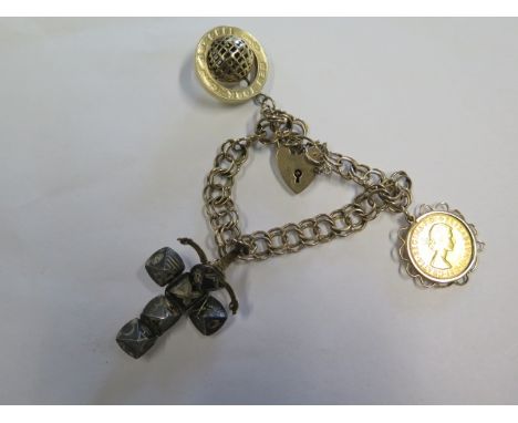 A 9ct yellow gold charm bracelet with a silver gilt masonic folding ball charm, a New York 1984-85 globe and a Elizabeth II 1