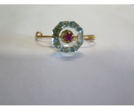 A French 18ct gold brooch with a Ruby set into a light blue hexagonal cut stone, possibly an aquamarine, 15mm x 15mm, weight 