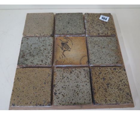 Nine Bernard Leach pottery stoneware tiles, the central tile decorated with a frog and marked in monogram BL and SI, circa 19