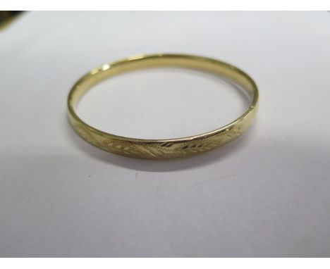 An 18ct yellow gold hinged bangle with a white gold slider, 6.2cm x 6.8cm, all round engraving, approx 9.9 grams in good cond