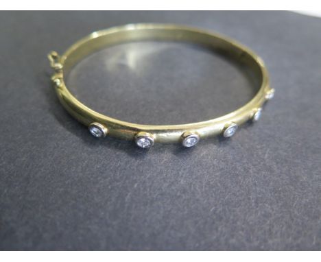 A yellow gold hinged bangle with 6 diamonds each approx 0.10ct, 6.5cm x 5.5cm external diameter, approx 20.8 grams and tests 