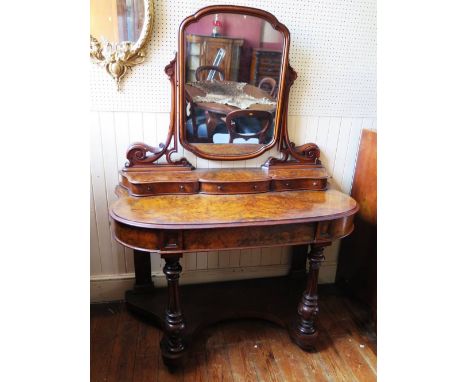 A Victorian Burr Walnut Dressing Table with swivel toilet mirror raised on carved supports with three drawers below and singl