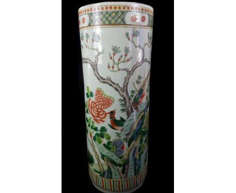 A Chinese porcelain stick stand, cylindrical, painted in famille rose colours with birds amid flowering peony trees, 57cm hig