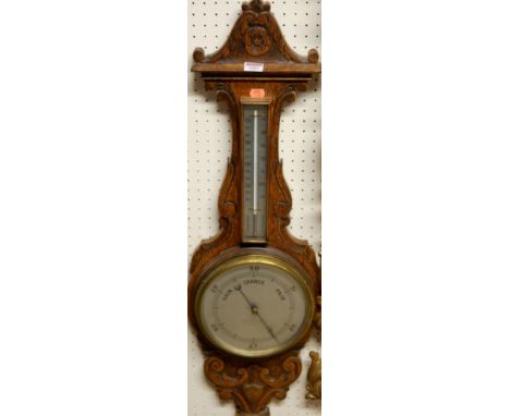 An early 20th century carved oak aneroid two dial wheel barometer