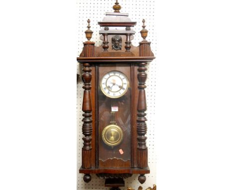 An early 20th century walnut Vienna style drop trunk wall clock, with pendulum