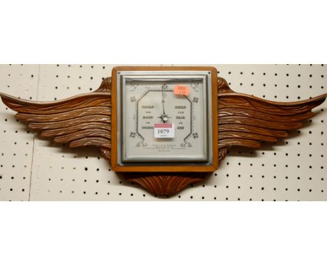 A mid 20th century aneroid square barometer, having a winged surround