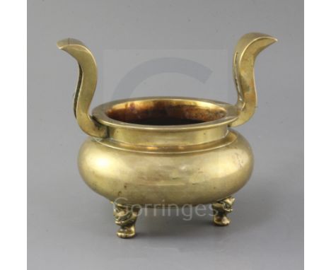 A Chinese bronze ding censer, 19th century, with flying scroll handles, three mask feet, h. 17.5cm, w. 20.5cm