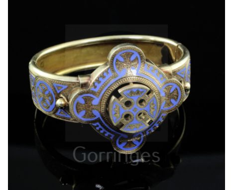A Victorian gothic style gold and pale blue enamel hinged bangle, with pierced central motif and continuous enamelled decorat
