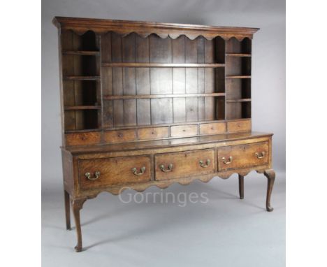 A George III oak dresser, with multi-shelf rack and six spice drawers over three long drawers, on squared cabriole legs, W.6f