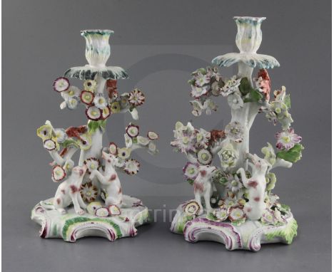 Two matching early Derby candlestick groups, c.1756-9 each modelled with squirrels in a tree with dogs seated below, on rococ