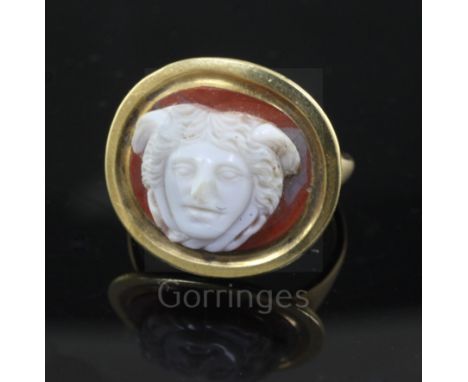 An antique gold and Roman? sardonyx cameo set oval ring, the cameo carved with the head of a man, size L.