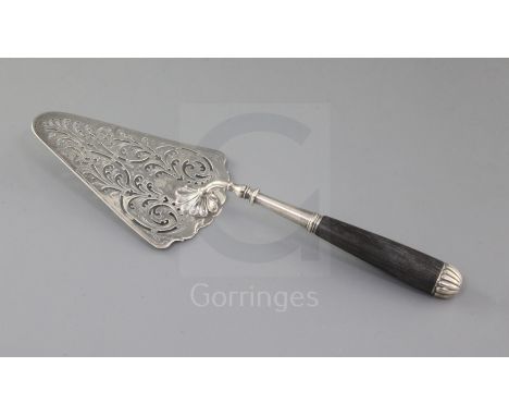 An early George III pierced silver fish slice, with ebonised handle and trowel shaped blade with pierced scroll decoration, L