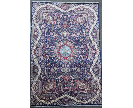 A Tabriz blue ground carpet, with field of scrolling geometric motifs and wavy border,