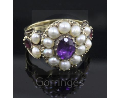 An antique gold, amethyst, garnet and pearl set cluster ring, with reeded shank, size M.