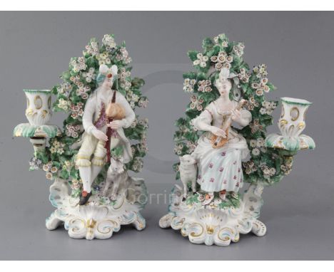 A pair of Derby candlestick groups of musicians, c.1770, the first a gentleman playing the bagpipes with a dog at his feet, t