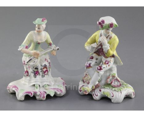 Two Derby 'Pale family' seated figures of musicians, c.1756-9, the first of a gentleman piper, the rococo scrollwork base enc