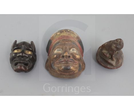 A Japanese bamboo seal in the form of a dog and two wood masks, 19th/20th century, the larger mask of a God of Wealth and the