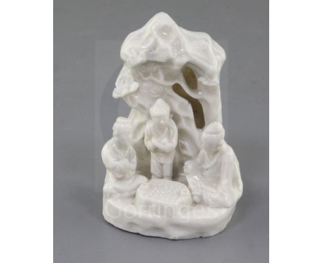 A Chinese Dehua blanc de chine group of Go players, Kangxi period, with three figures underneath a prunus tree, height 9.5cm,