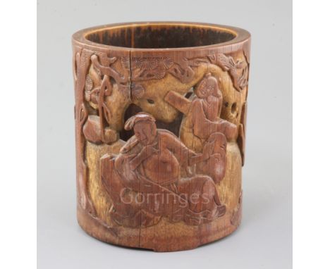 A Chinese bamboo brush pot, carved in low relief and pierced with two figures of a safe and attendant seated beneath a pine t