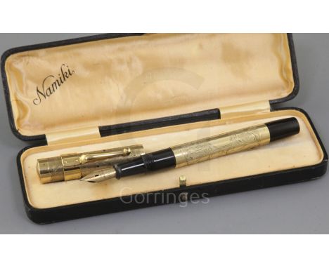 A cased Namiki 14k rolled gold fountain pen, with foliate engraved barrel stamped 'Namiki Made in Japan', clip and filler lev
