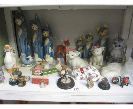 A shelf of animal figures including cats and pigs