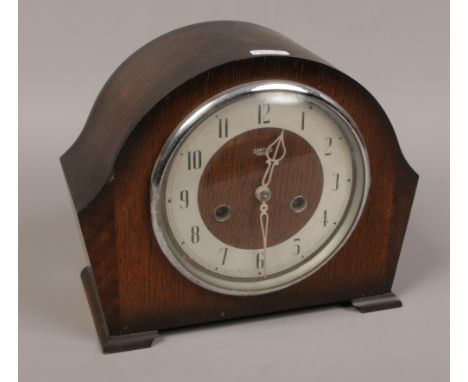 A Smiths Enfield oak cased mantle clock chiming on a coiled gong with pendulum and key. 
