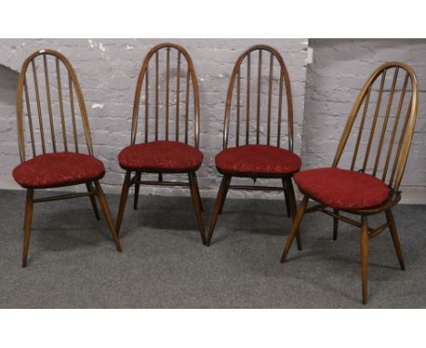 A set of four Ercol spindle back dining chairs with red upholstered seat cushions. 