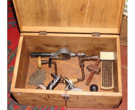 A pine trunk with reproduction travel stickers and a collection of vintage tools including Stanley plane and a brass plaque f
